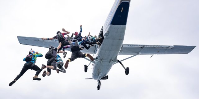 Group of licensed skydivers exiting from the airplane