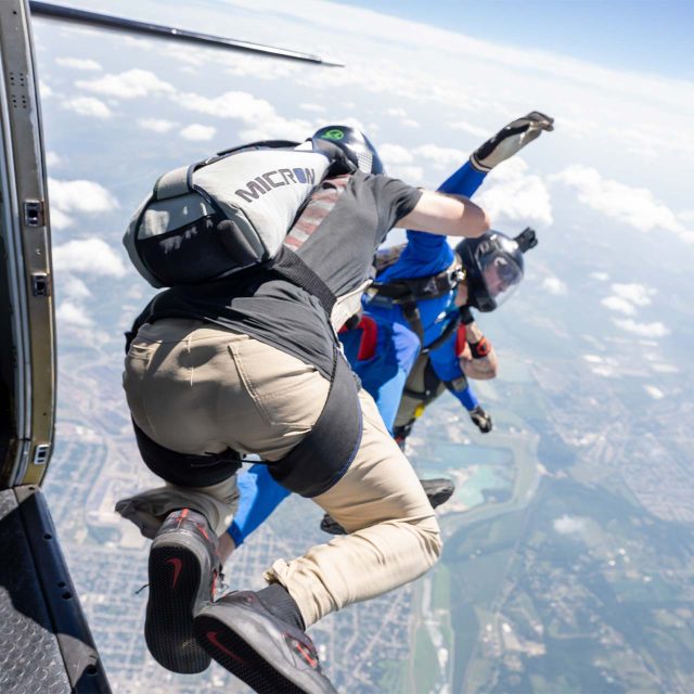 Two AFF instructors exit holding on to either side of an AFF student while skydiving in Dayton