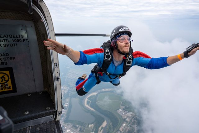 A solo skydiving student exits the aircraft keeping his eyes directed toward the front of the plane