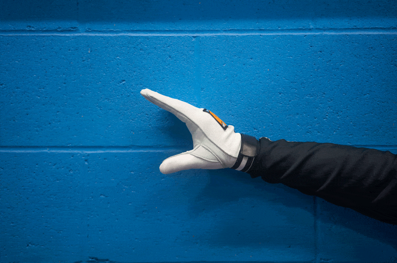 Hand wearing a white glove giving the check knees and toe tap hand signal against a blue background.
