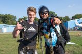 Shortly after landing from skydiving in Dayton a tandem instructor and student smile and pose for a photo