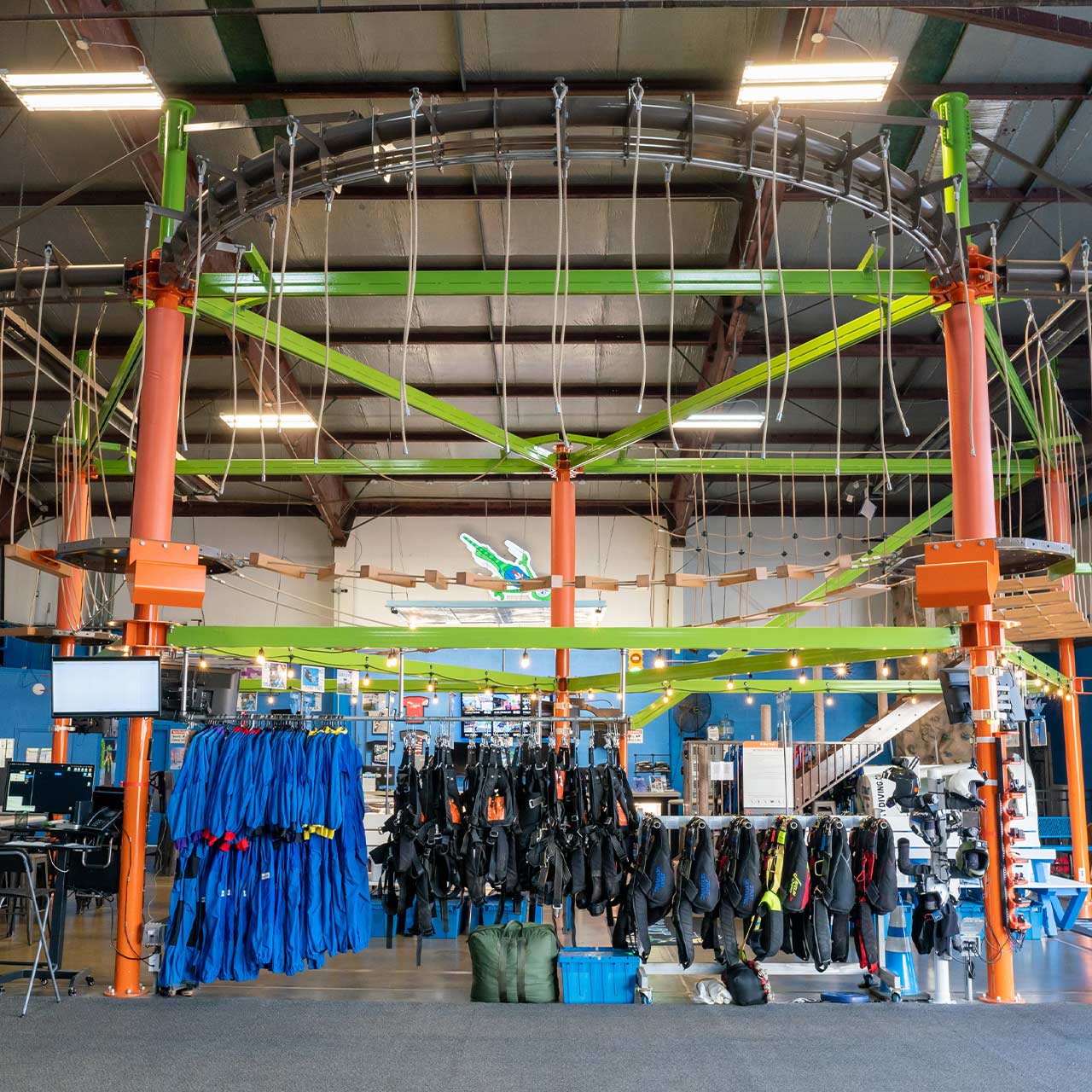Interior view of the lime green and orange high ropes course within the hangar at Start Skydiving.