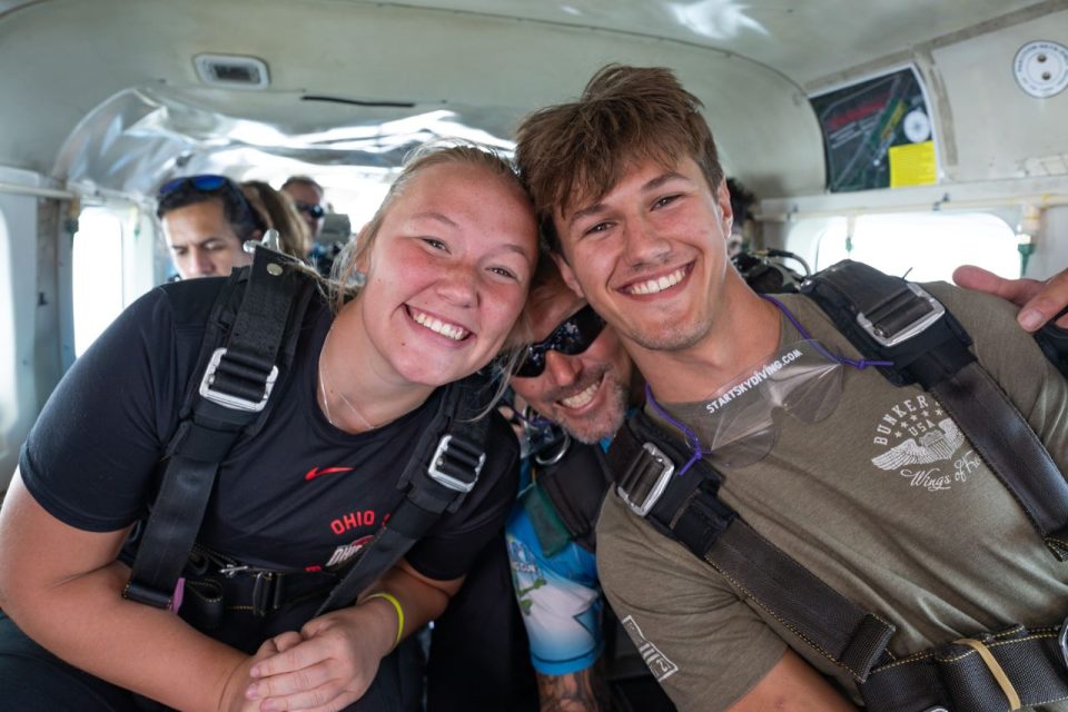 Tandem jumpers smiling in the airplane.
