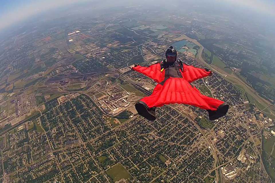 Skydiver in a red wingsuit over Start Skydiving in Ohio