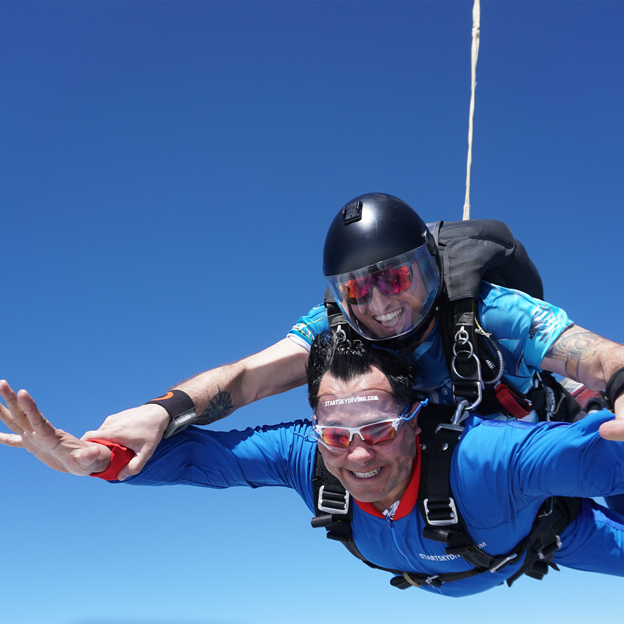 A tandem skydiving instructor and tandem student enjoy freefall while skydiving in Ohio.