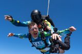 A tandem student yells with excitement while in freefall at Start Skydiving